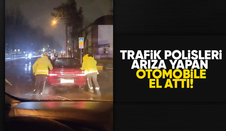 Arızalanan otomobili trafik polisleri yağmurun altında itti