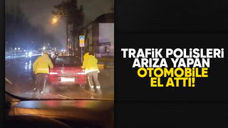 Arızalanan otomobili trafik polisleri yağmurun altında itti