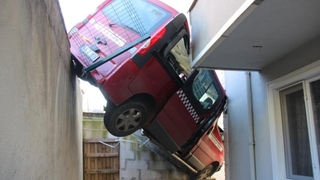 Freni boşalan dolmuş taksi, bina boşluğunda asılı kaldı