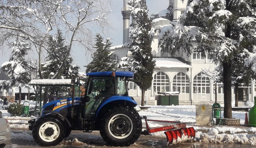 Akyazı'da muhtar ilçe merkezinde traktörle kar küredi