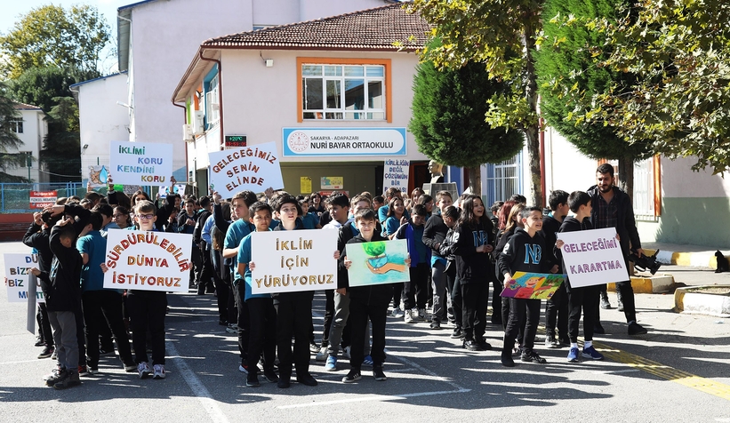İklim değişikliği ile mücadeleye dikkat çekmek için bando eşliğinde yürüdüler