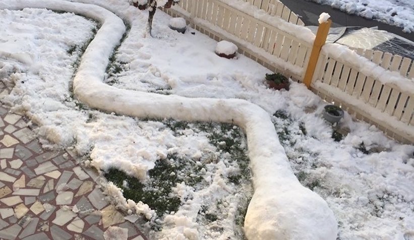 Sapancalı kadın evinin bahçesine kardan yılan yaptı