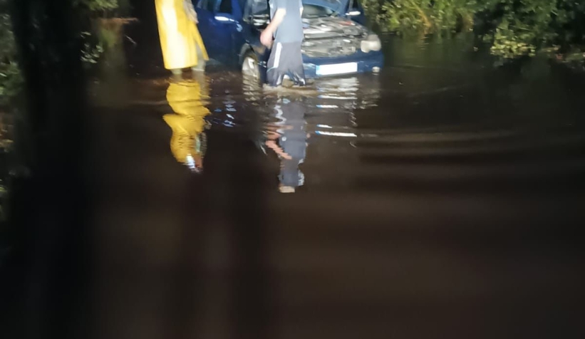 Yağışta göle dönen sokakta araçta mahsur kaldı