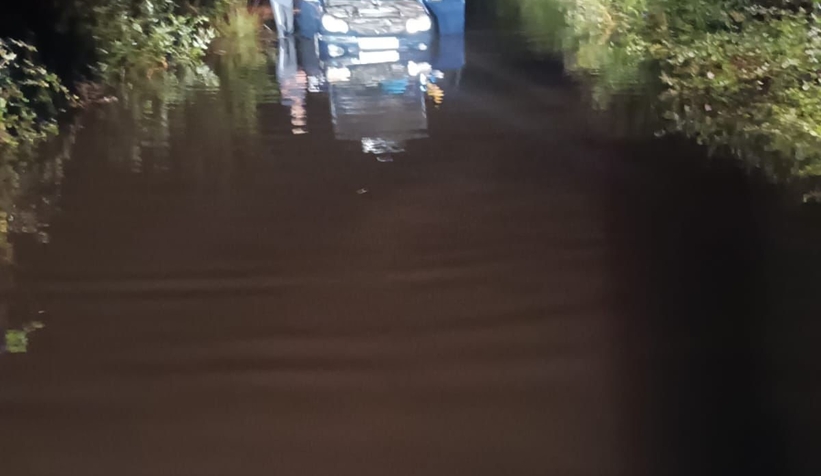 Yağışta göle dönen sokakta araçta mahsur kaldı