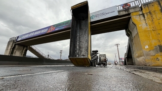 Kamyonun açılan damperi üst geçitte asılı kaldı