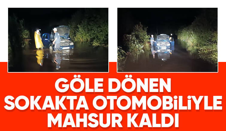 Yağışta göle dönen sokakta araçta mahsur kaldı