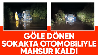 Yağışta göle dönen sokakta araçta mahsur kaldı